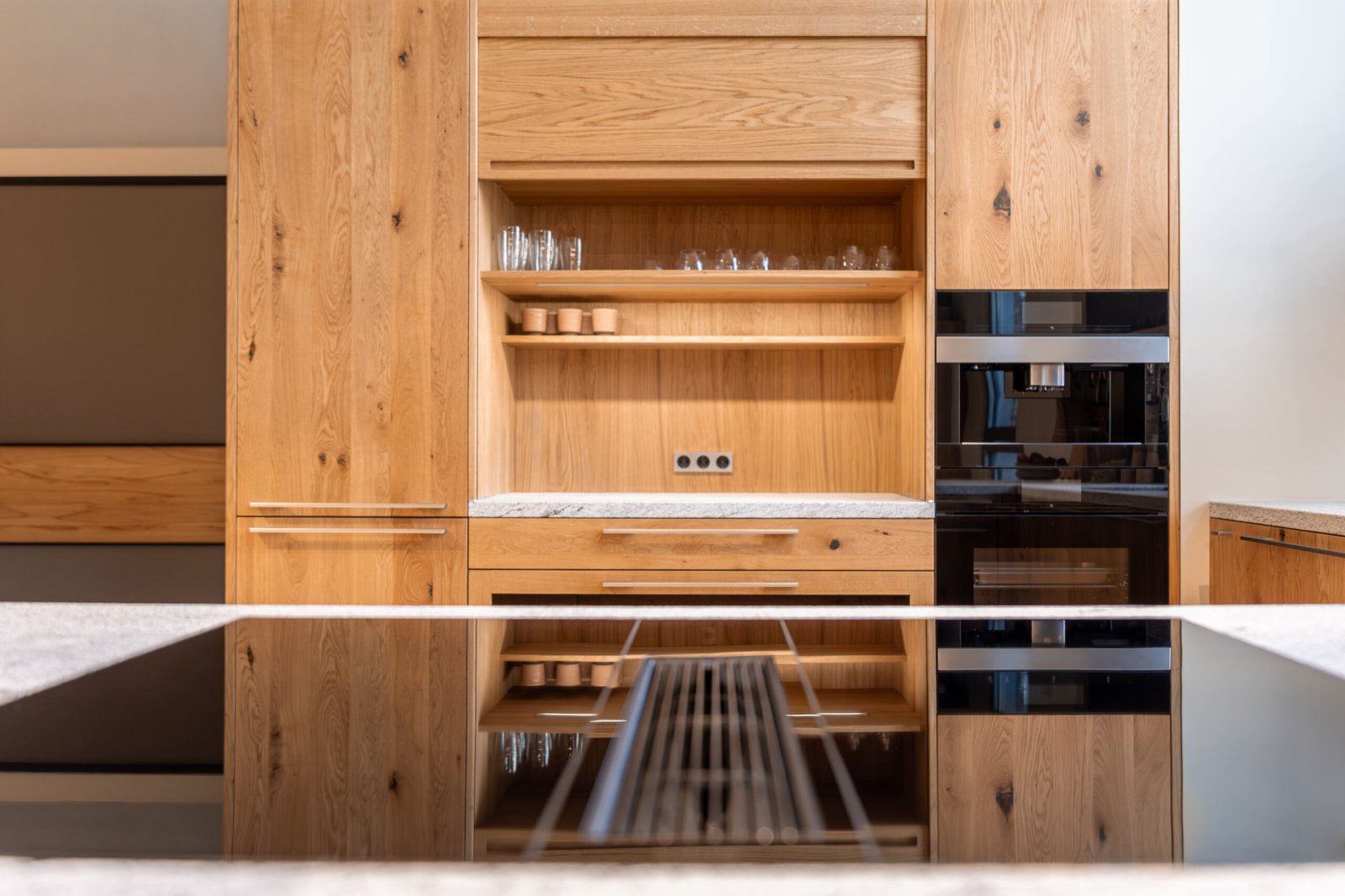 Spacious modern kitchen with high-quality wooden cabinets, built-in appliances, and lighting.